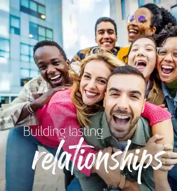 Group of smiling friends taking a picture outside of a modern office building