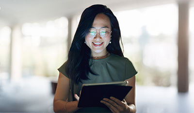 Person standing indoors while using a digital tablet.