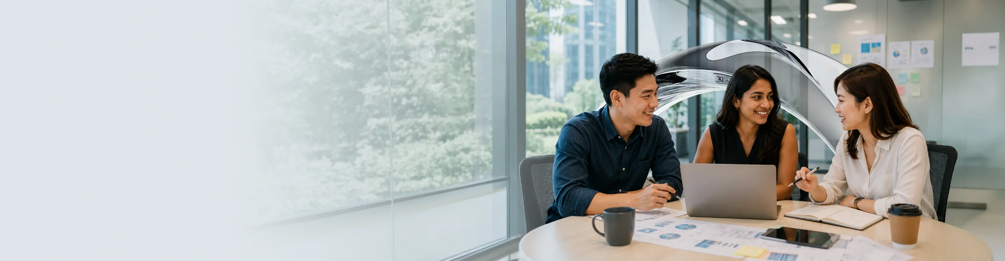 Three diverse colleagues collaborate happily in a bright office meeting