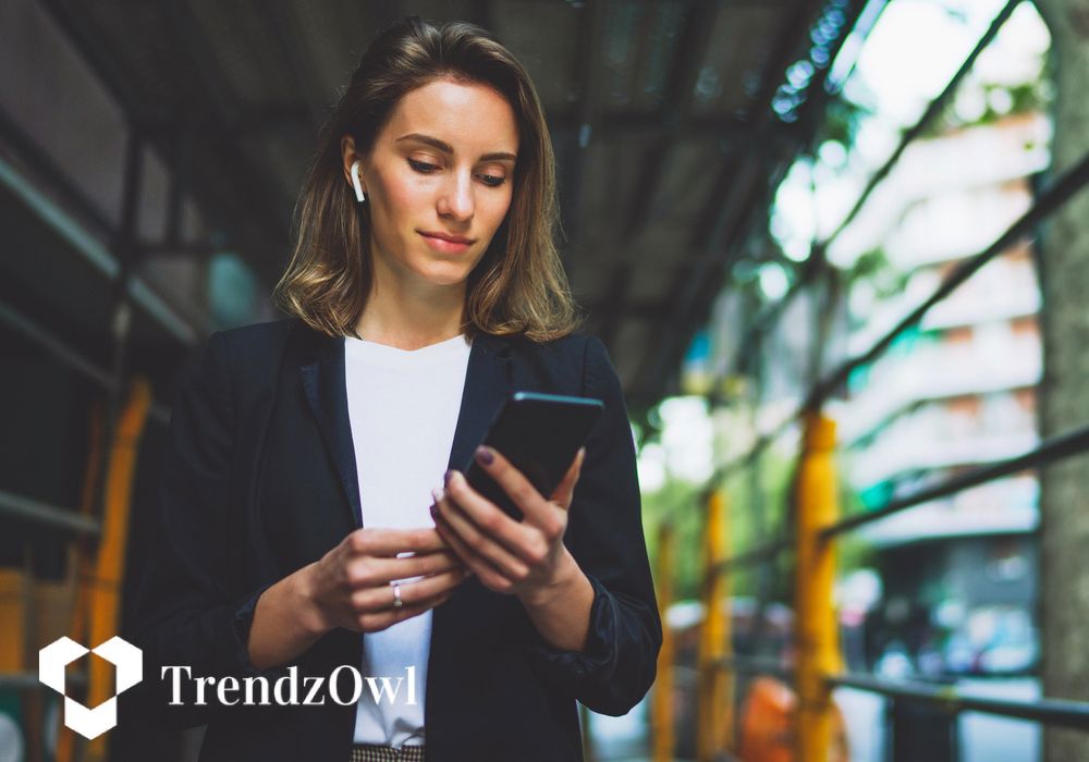 Businesswoman holding her phone, illustrating tech trends to watch in 2026 and beyond.