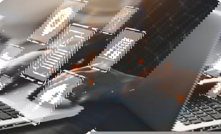 Person typing on a laptopn wisome 3D objects floating over the image