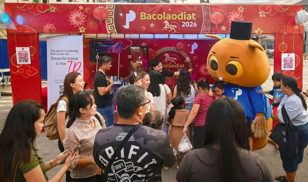 People interacting with a costumed character during Bacolaodiat Festival celebrations.