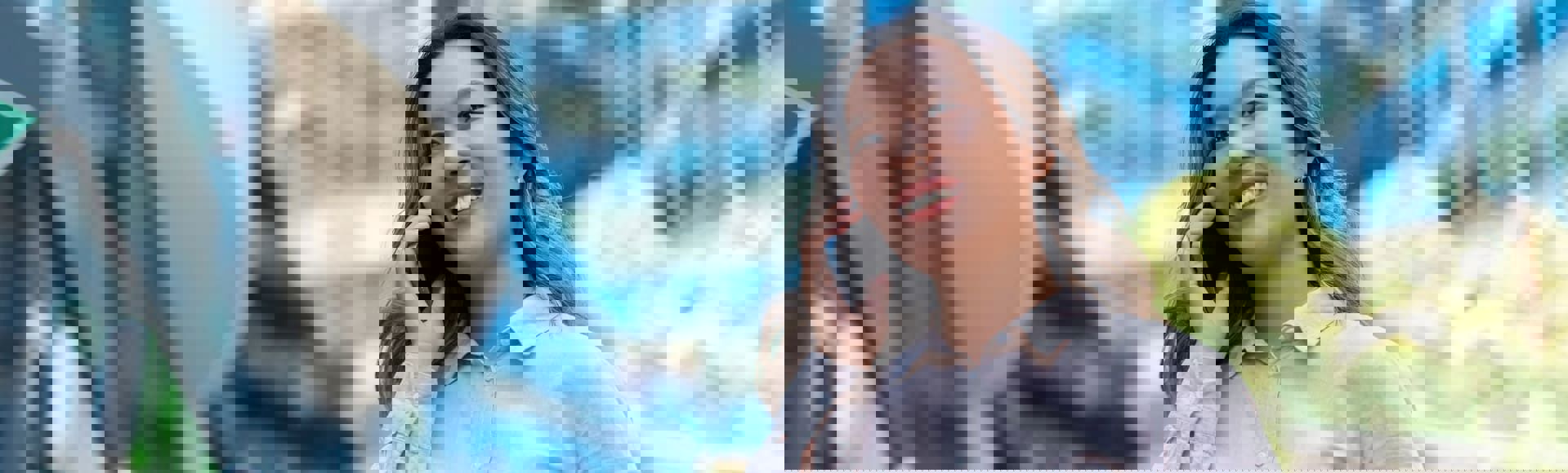 Smiling Asian business woman talking on the phone in the streets