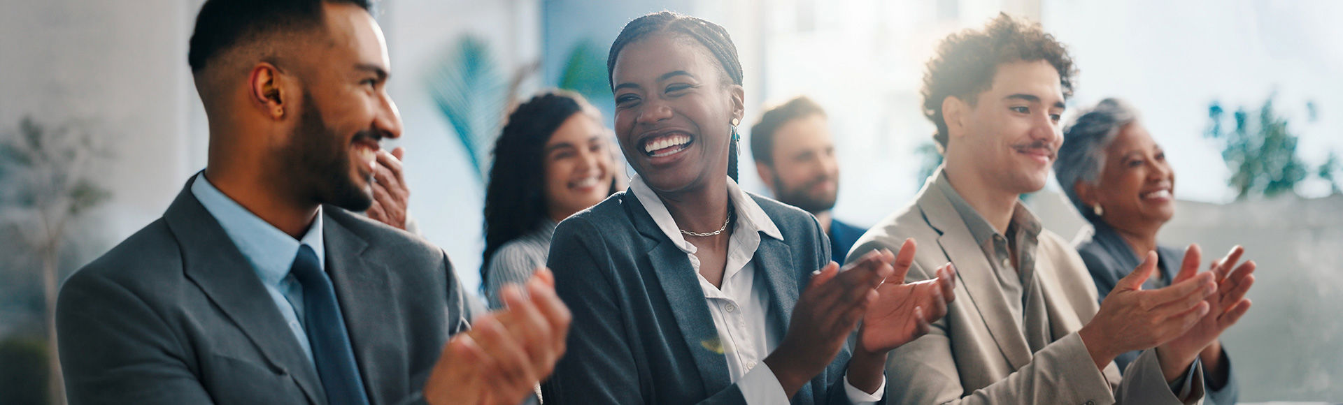Diverse group of professionals celebrating a collective achievement in a corporate setting.