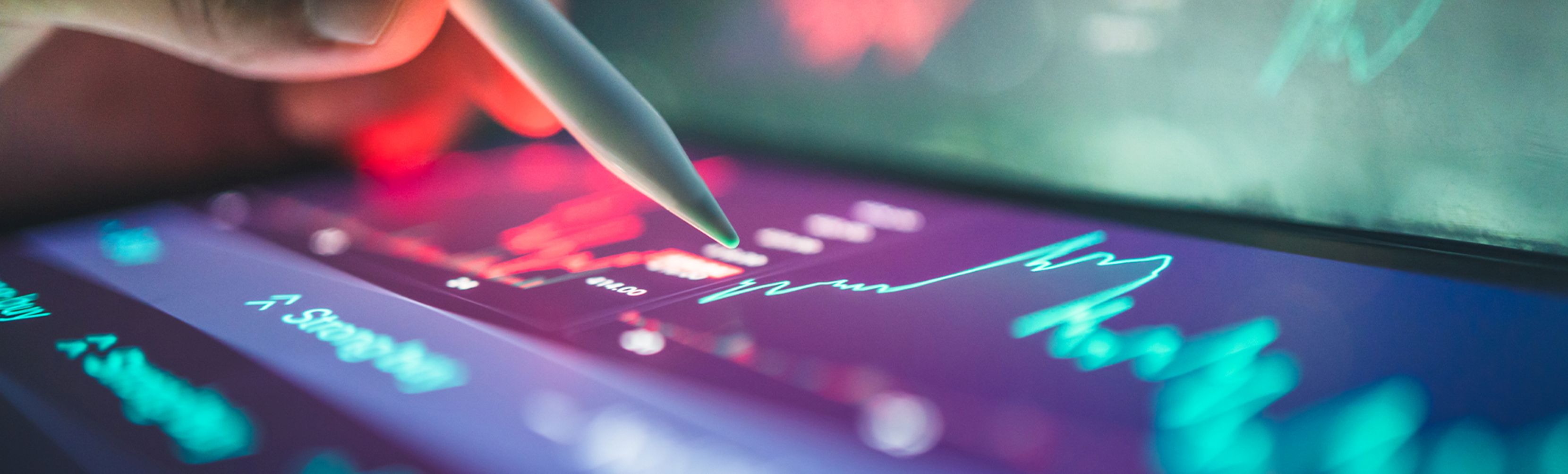 Hand holding a pencil while clicking on a computer screen.