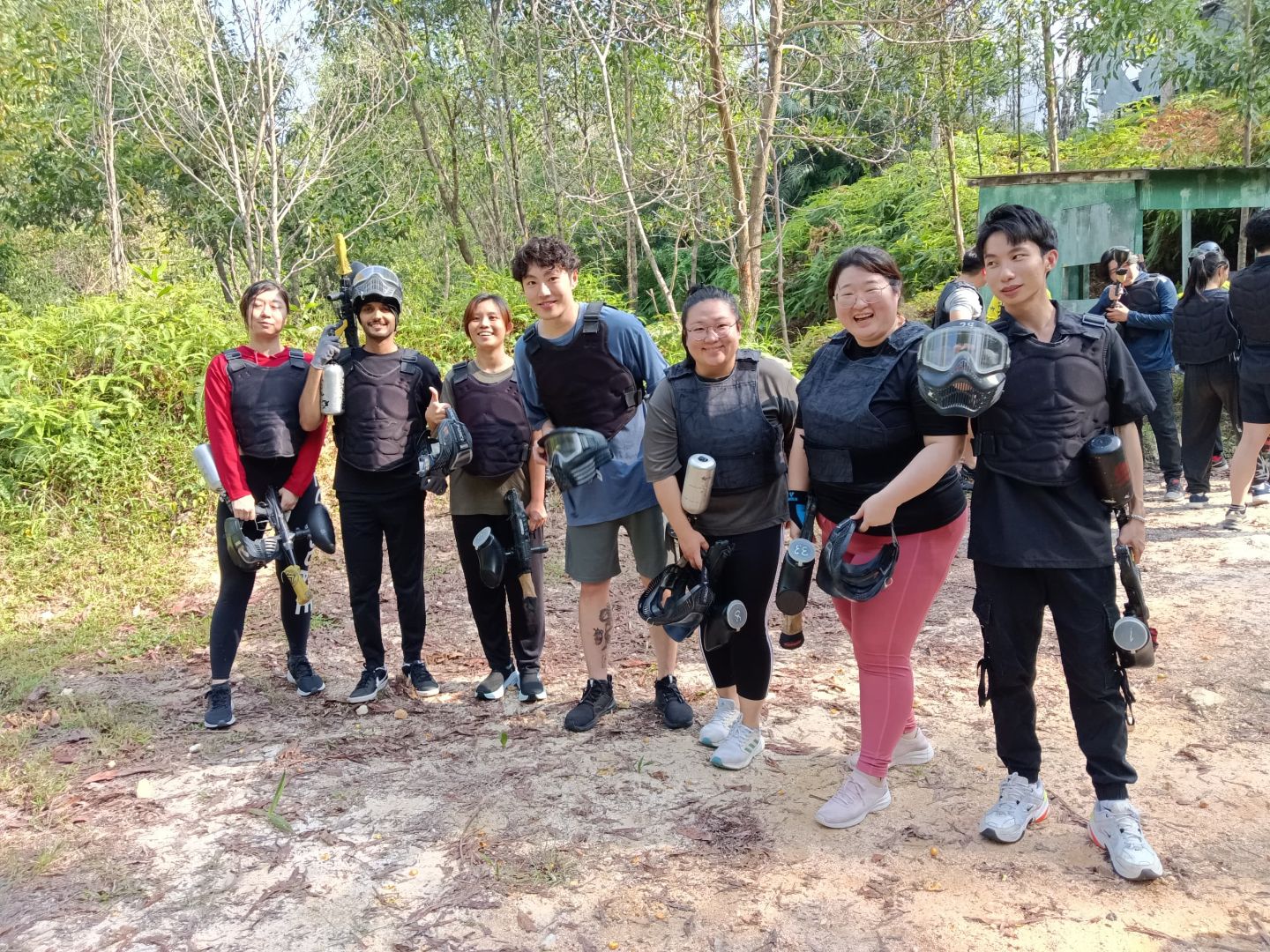 TP employees wearing protective gear after outdoor paintball game