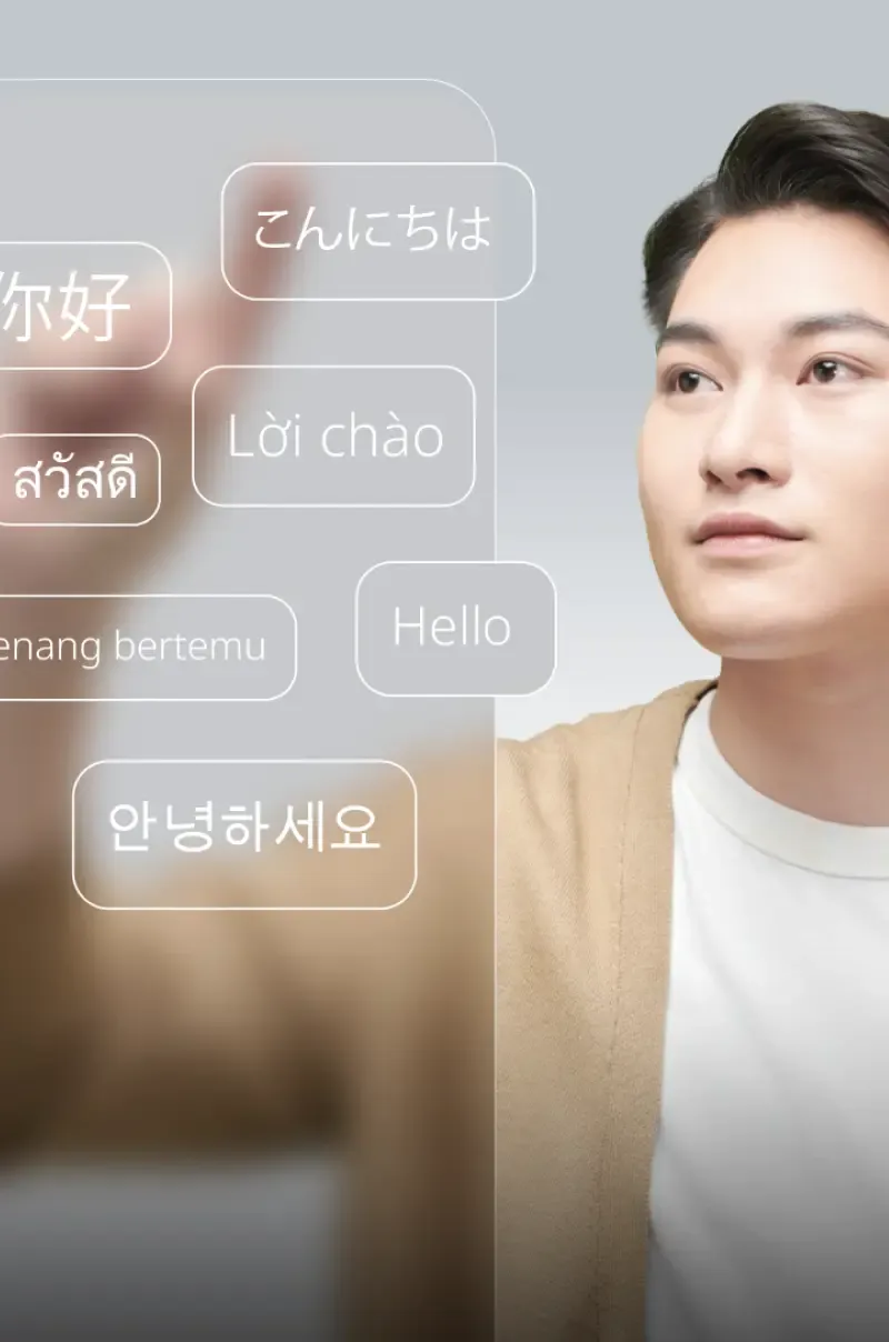 Young Asian man interacting with a 3D multilingual interface, symbolizing global connectivity.