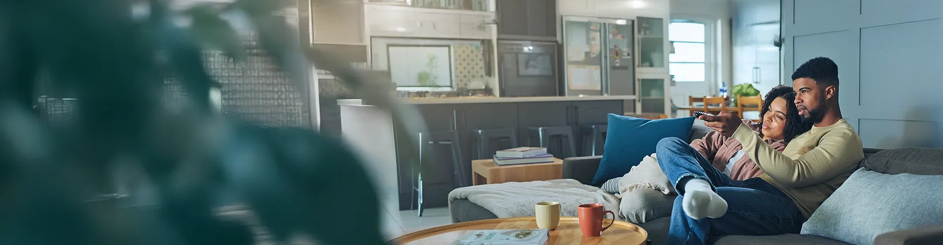 Couple watching television together while sitting comfortably on a sofa at home.