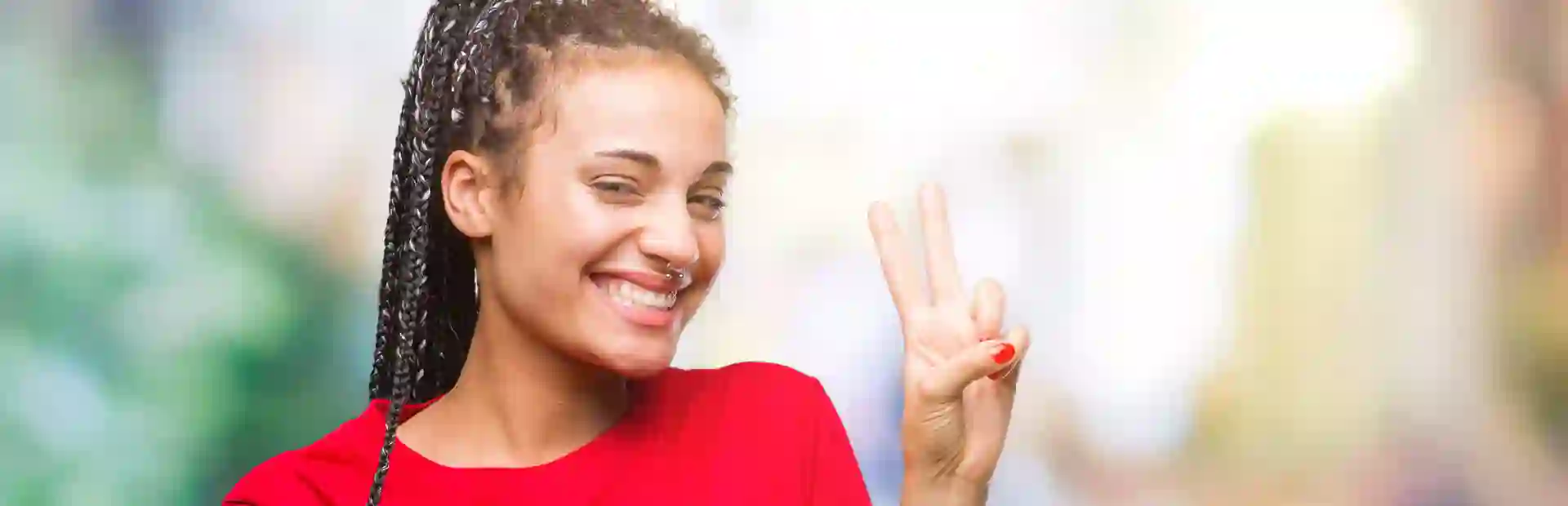 Smiling young woman making a peace sign gesture with their fingers.