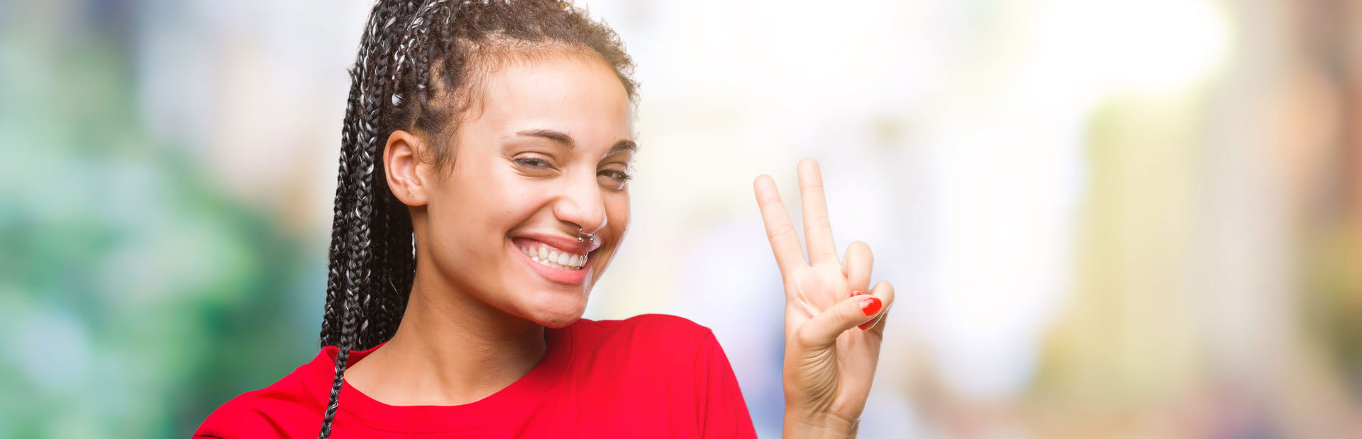 Smiling young woman making a peace sign gesture with their fingers.