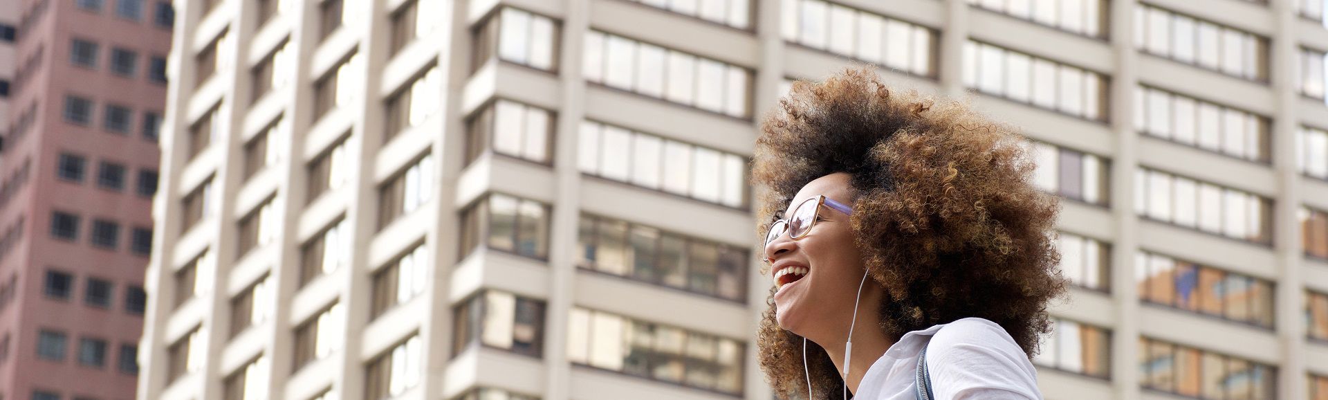 Young woman laughing while walking with headphones, blog on TP’s year-round support for women and families in Tunisia. Young woman laughing while walking with headphones, blog on TP’s year-round support for women and families in Tunisia.