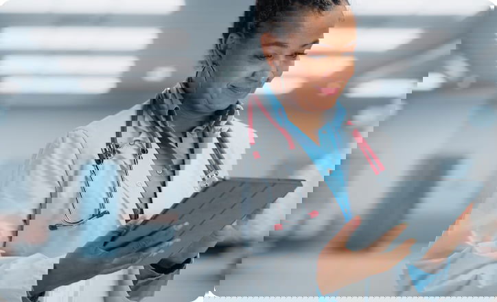 African doctor analyzing pacient profile on a tablet