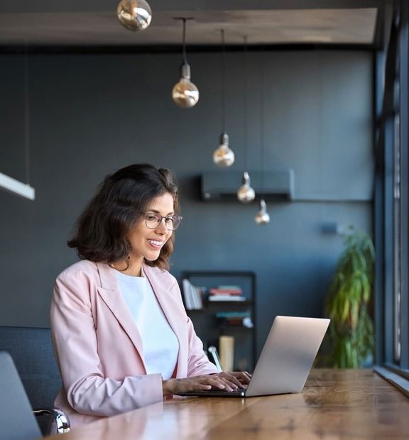 Smiling business woman working on her laptop