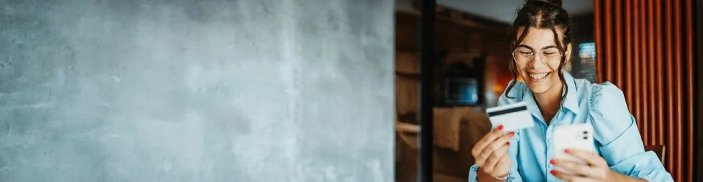 Woman with a smartphone and a card in her hand