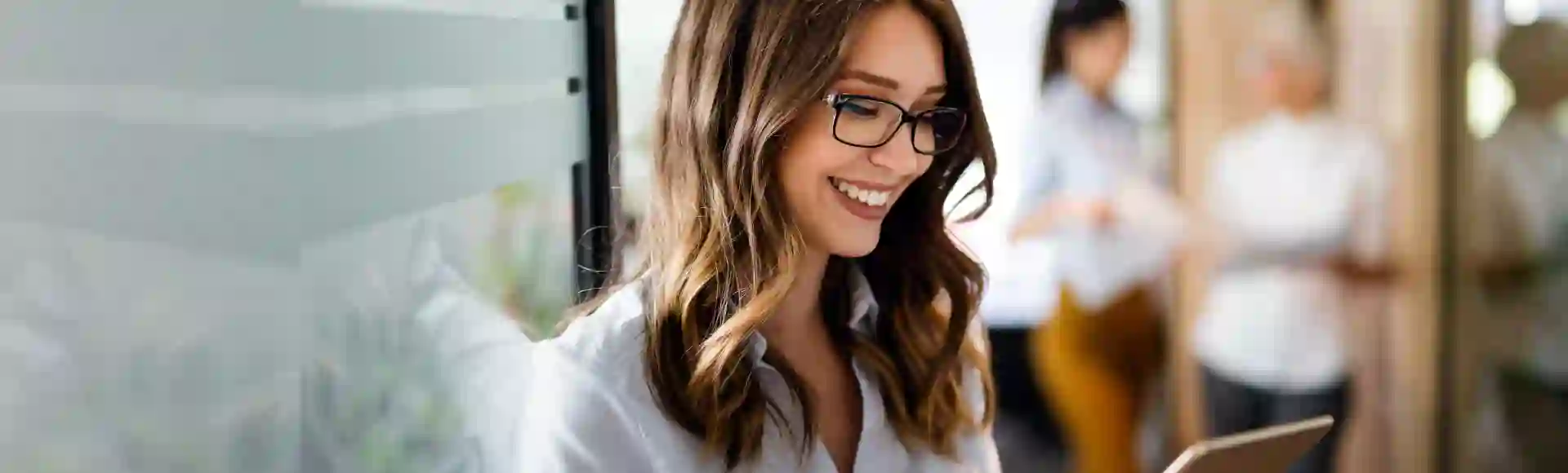 Smiling woman working on a tablet.