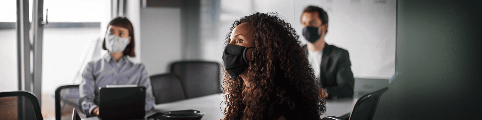 Team members using masks during a team meeting at the office