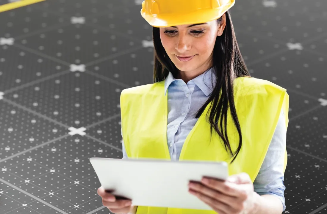 Professional wearing a helmet while reviewing a checklist on a clipboard.