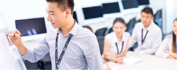 Professional presenting ideas on a whiteboard during a team meeting.