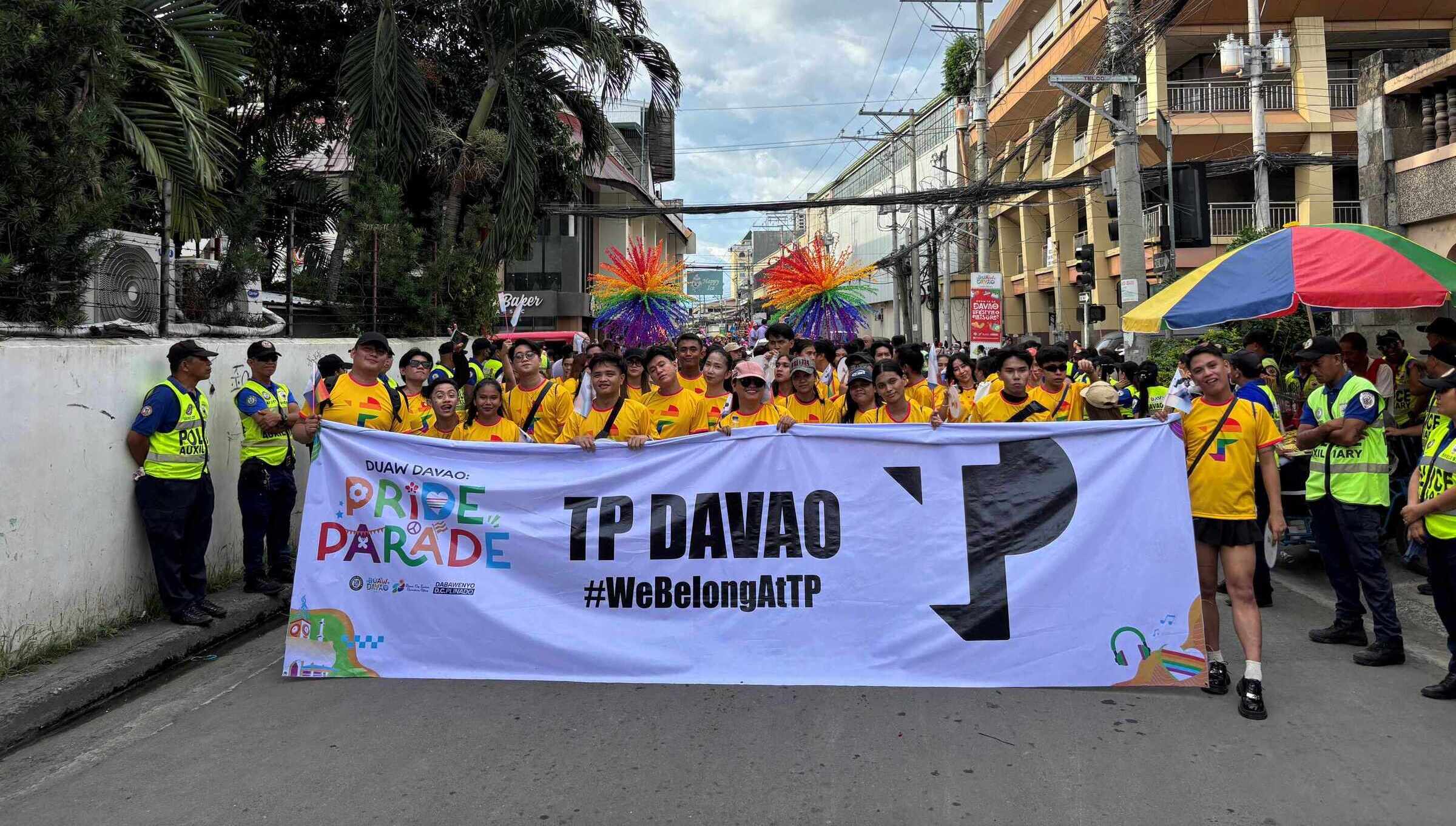 TP Davao employees marching in Pride parade holding large event banner