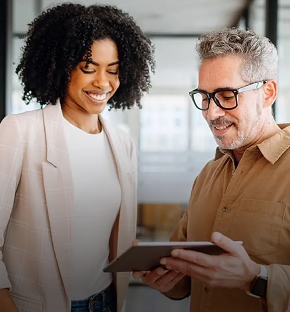 A man and a woman looking into a tablet