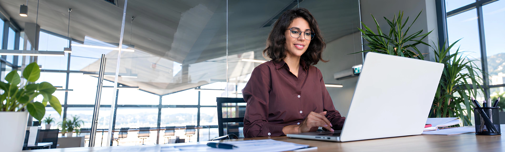 Latin businesswoman working on a computer, focused on business success.