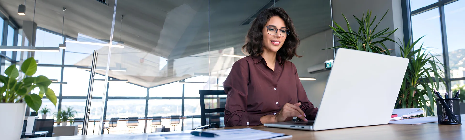 Latin businesswoman working on a computer, focused on business success.
