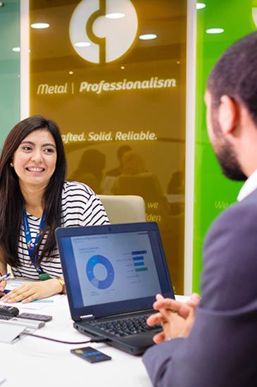 A laptop displays a graph while a woman smiles at a man in an office. text on the backdrop reads: "global | professionalism." A laptop displays a graph while a woman smiles at a man in an office. text on the backdrop reads: "global | professionalism."