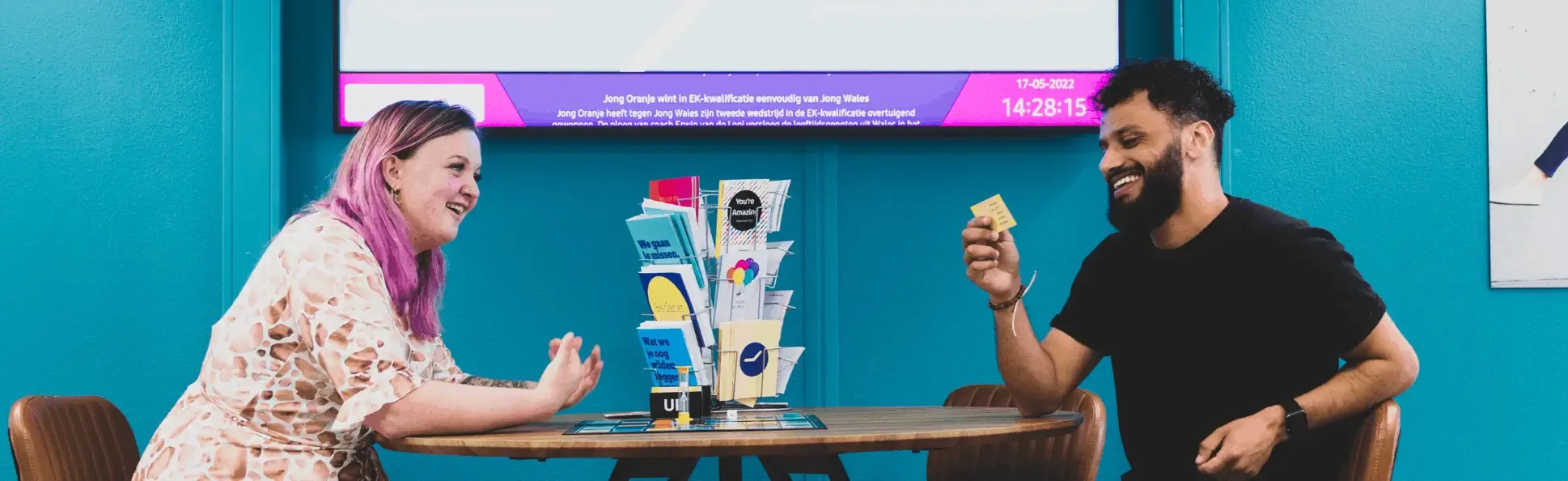 Two persons sitting in a table chatting.