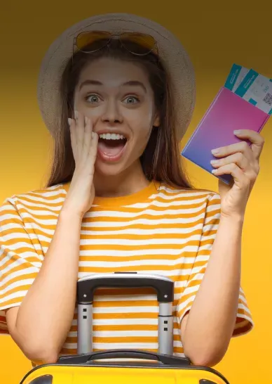 Excited young woman in striped shirt holding passport with boarding passes and suitcase on yellow background.