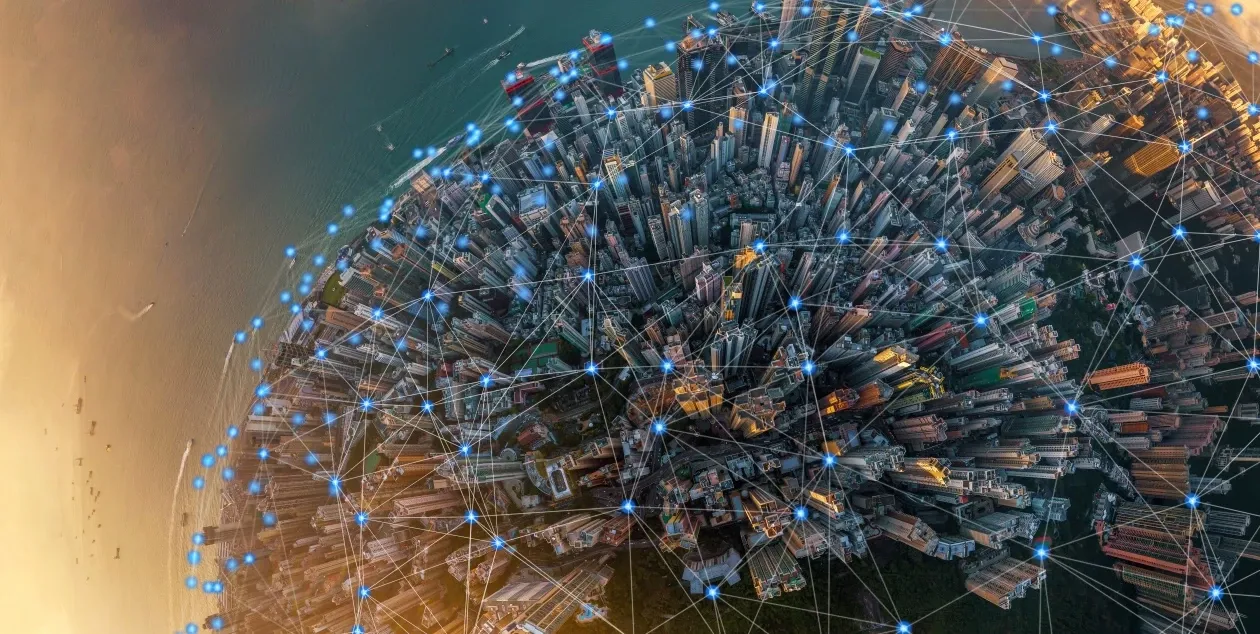 Aerial view of a city with glowing nodes and lines illustrating digital connectivity and networks.