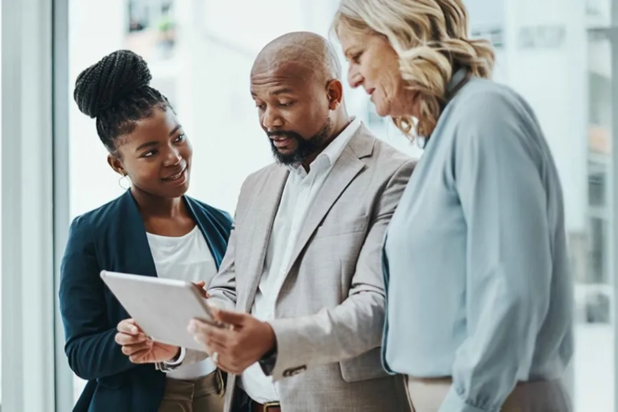 Colleagues reviewing strategies on a tablet, reflecting AI enabled operational excellence.