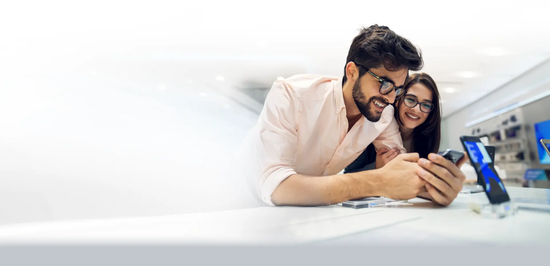 AI by TP displayed over a couple testing a smartphone in a store.