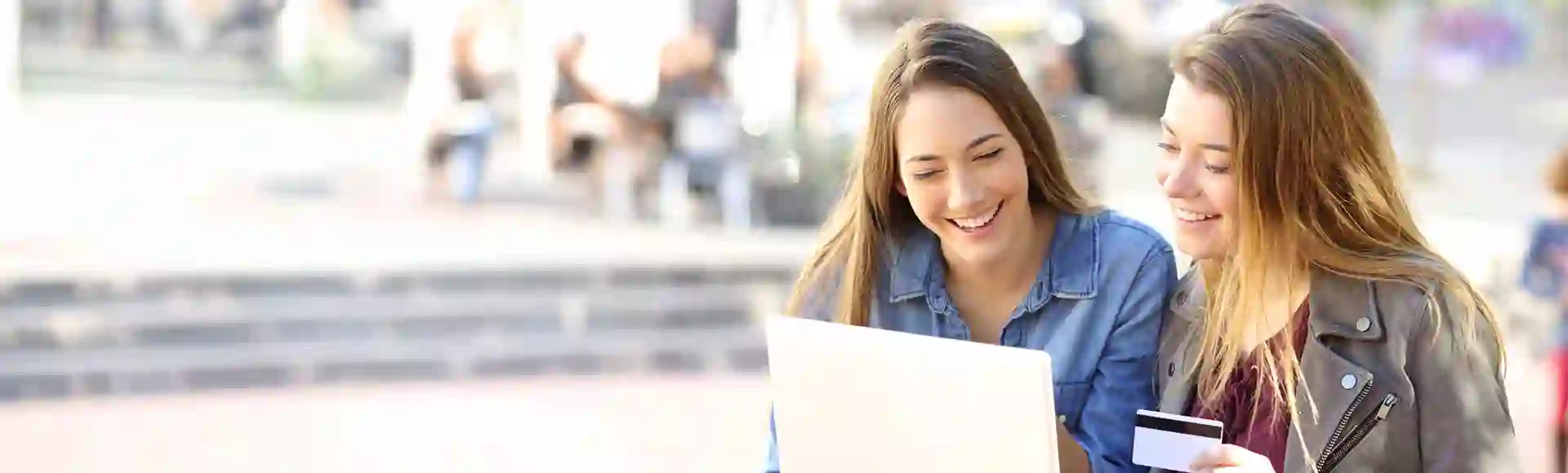 Friends smiling while browsing laptop