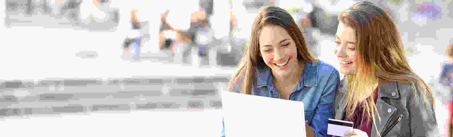 Friends smiling while browsing laptop