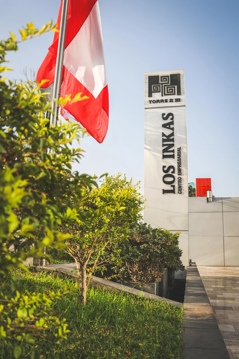 Los Inkas business center with Peruvian flag and surrounding greenery.
