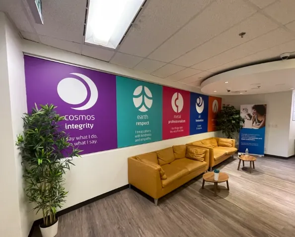 Office lounge area with yellow sofas and colorful value statement wall displays