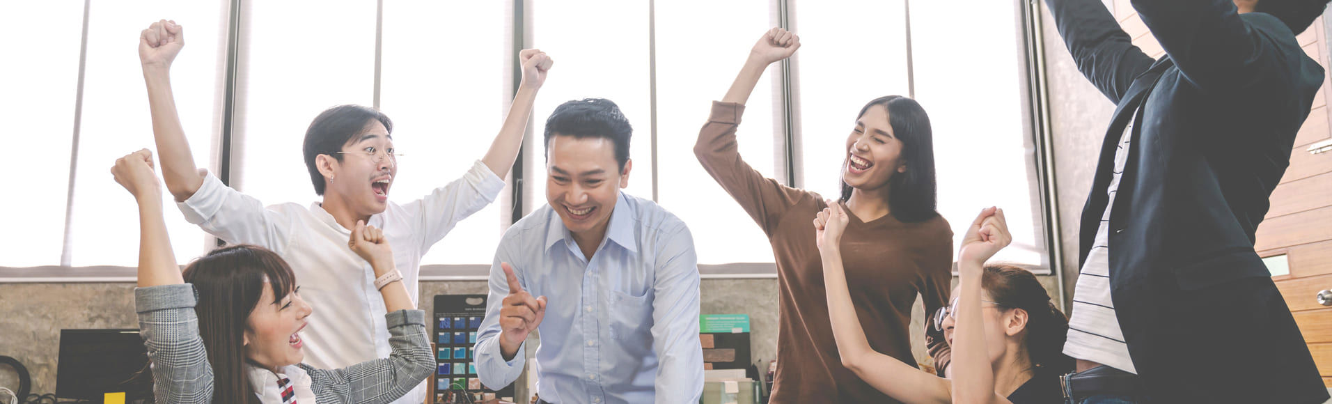 Asian colleagues celebrate a team win, marking TP’s multiple CCAM 2025 awards.