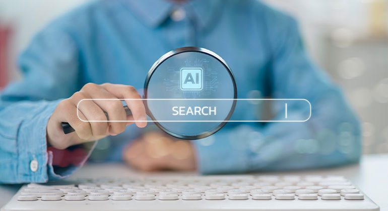 Person using a magnifying glass over a digital AI-themed search bar on a computer keyboard.