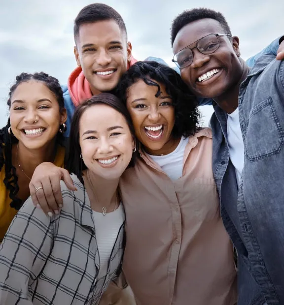 Three women and two men smiling for a photo.