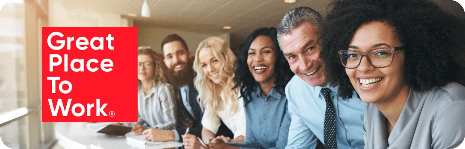 Smiling workers celebrate Great Place to Work certificate