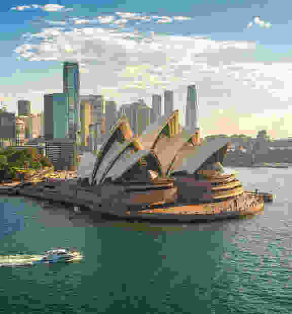 Aerial view of the beautiful and modern city of Sydney, featuring the iconic Opera House on a sunny day.