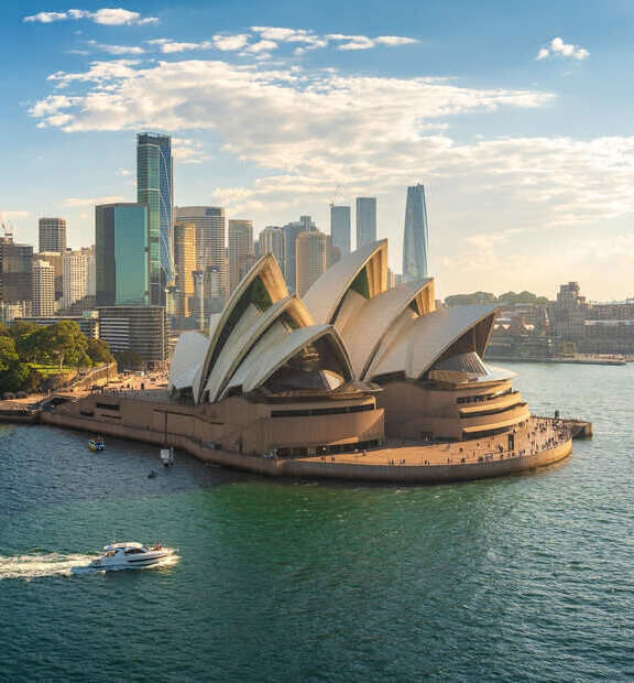 Aerial view of the beautiful and modern city of Sydney, featuring the iconic Opera House on a sunny day.