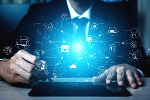 Business professional using a tablet with a connected digital network of commerce and service icons.