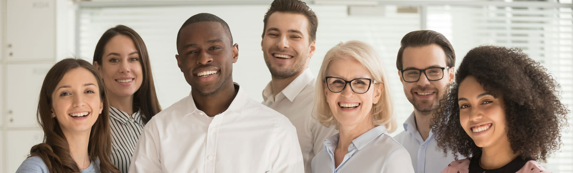 Diverse group of company employees standing together in a professional and friendly environment.