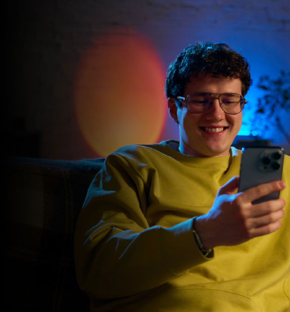 Joven sonriendo revisando su celular 