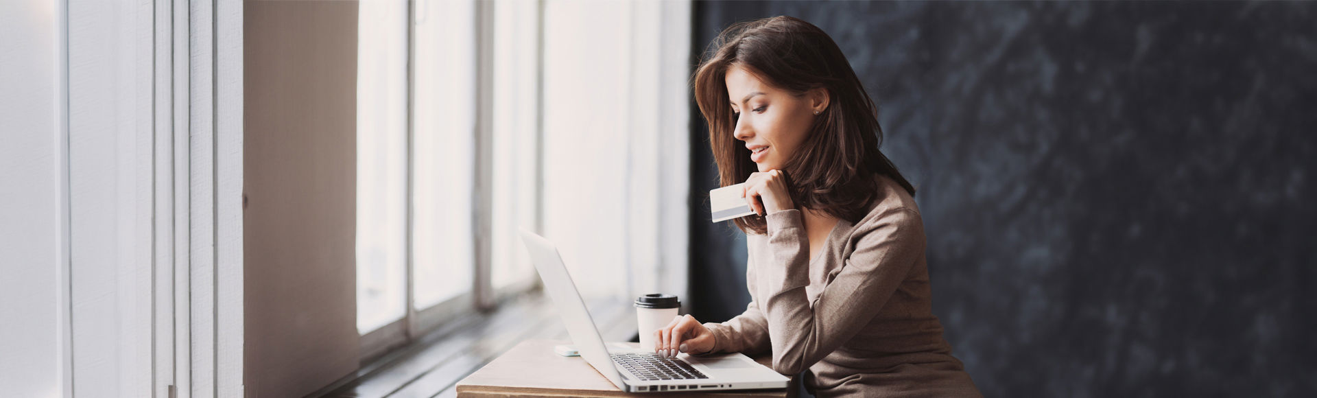 Femme devant son ordinateur avec une carte bancaire
