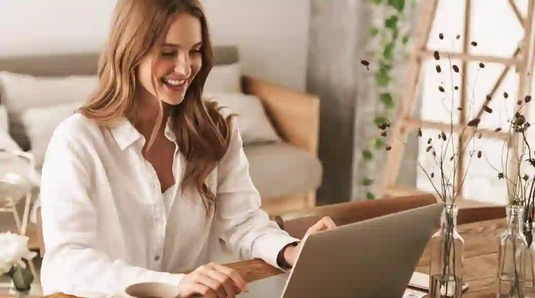 Smiling woman working on her laptop at home
