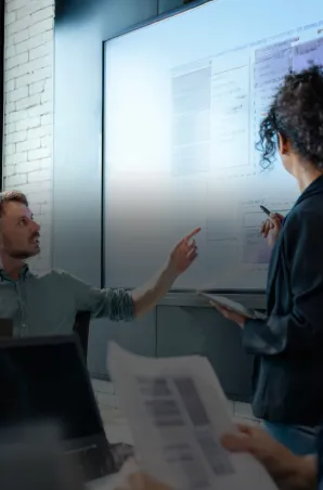 Team reviewing a technical architecture diagram on a large screen during a project discussion.