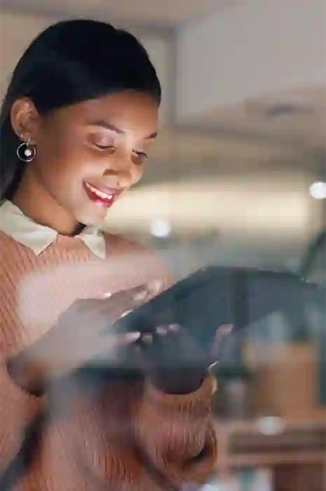 TP employee smiling while using a tablet in a modern office