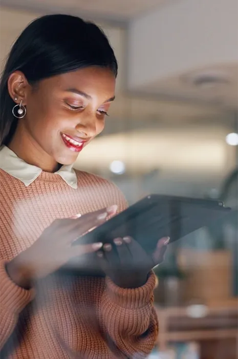 TP employee smiling while using a tablet in a modern office TP employee smiling while using a tablet in a modern office